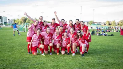 Das BDO-Damenteam in roten Trikots posiert lachend und jubelnd auf dem Fußballfeld nach einem Spiel – Symbol für Teamgeist und Zusammenhalt